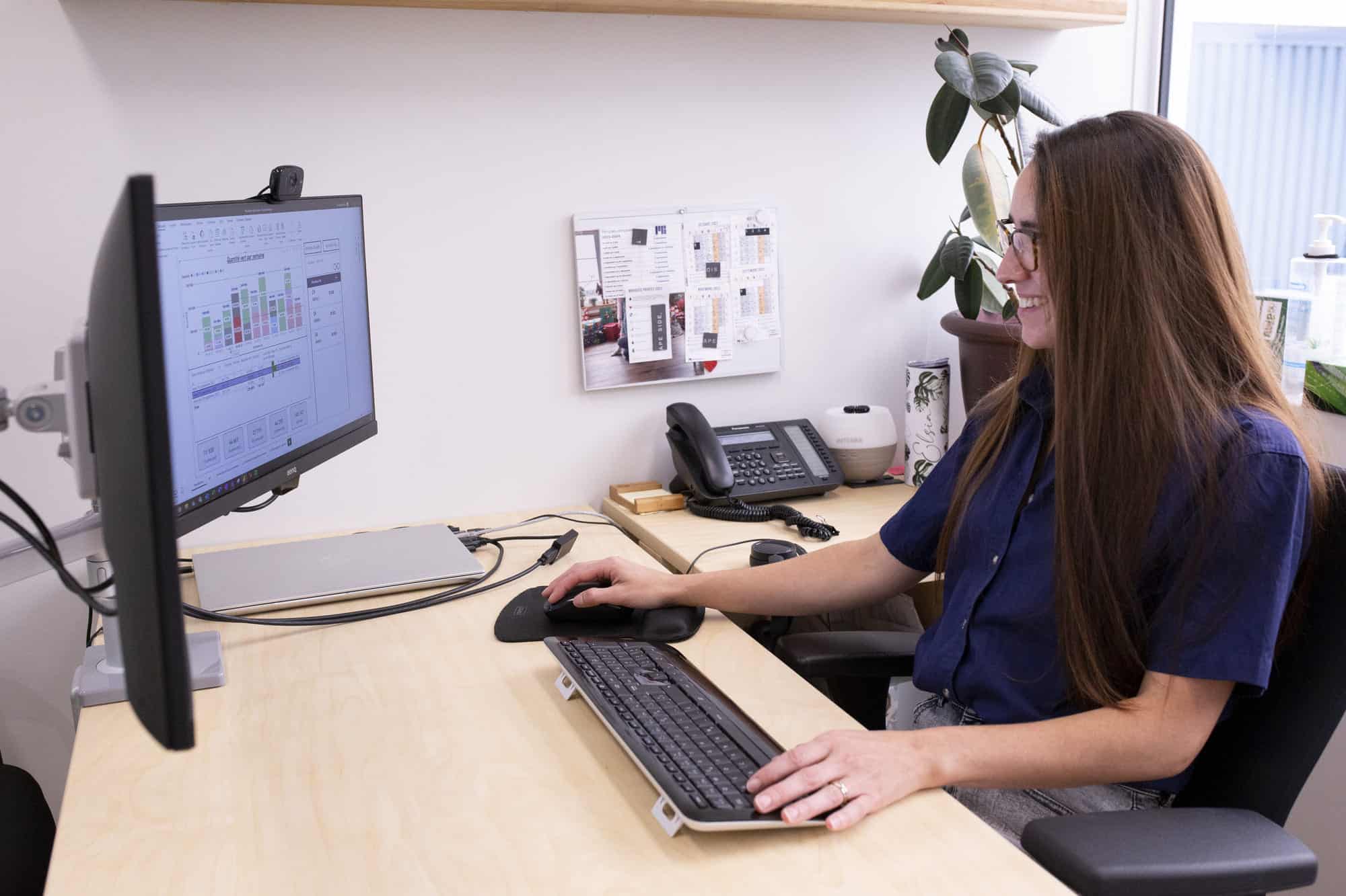 Femme travaillant à l'ordinateur dans un bureau moderne.
