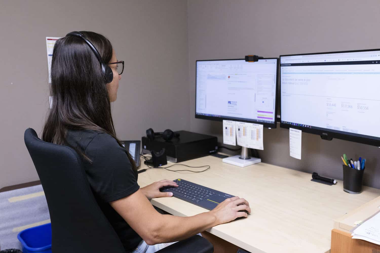 Femme avec un casque d'écoute travaillant à un ordinateur