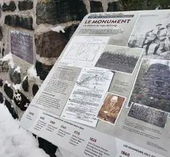 Panneau d'information sur le monument historique enneigé.