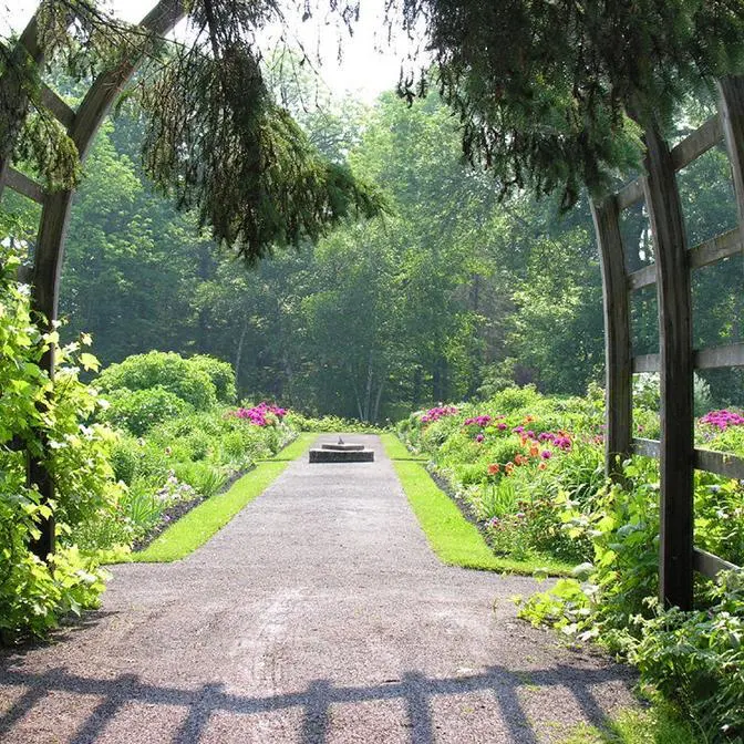 Allée fleurie dans un jardin verdoyant.