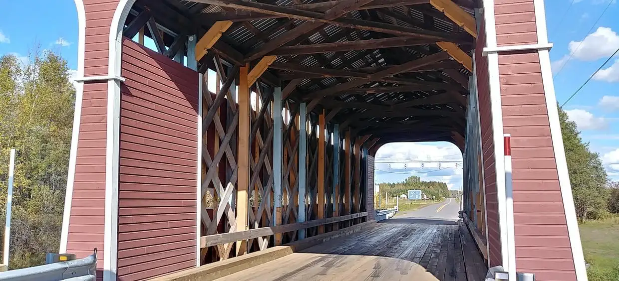 Pont couvert en bois sur route rurale