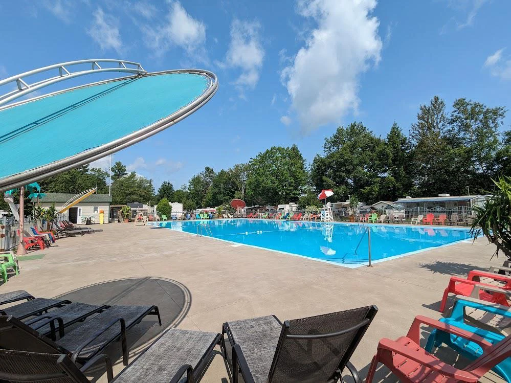 Piscine extérieure avec chaises longues colorées.