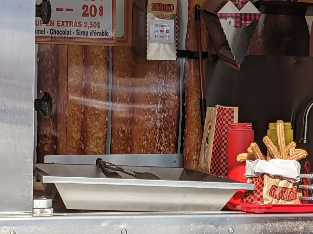 Stand de churros avec accessoires et sauce.