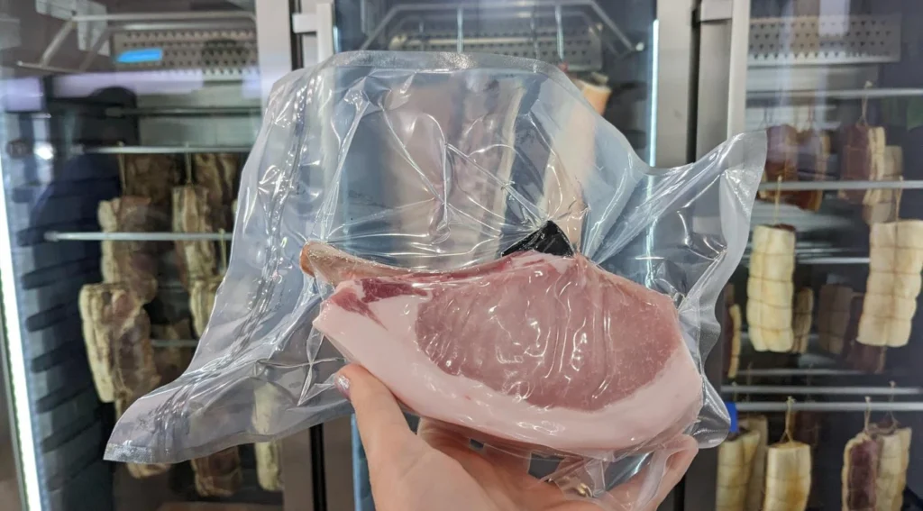 Côte de porc sous vide devant réfrigérateur
