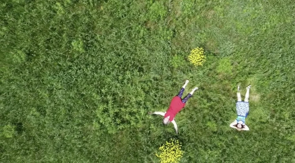 Deux personnes allongées sur l'herbe.