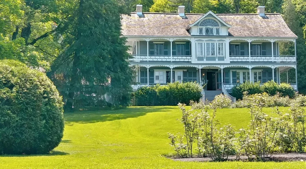 Maison historique blanche entourée de verdure