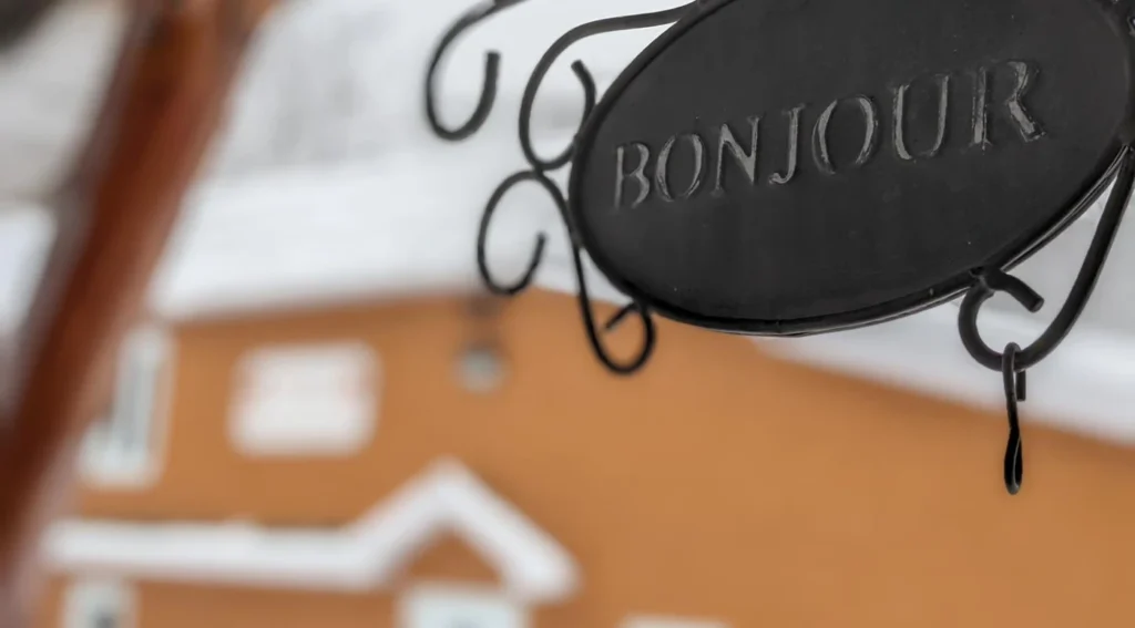 Enseigne bienvenue noire devant maison floue