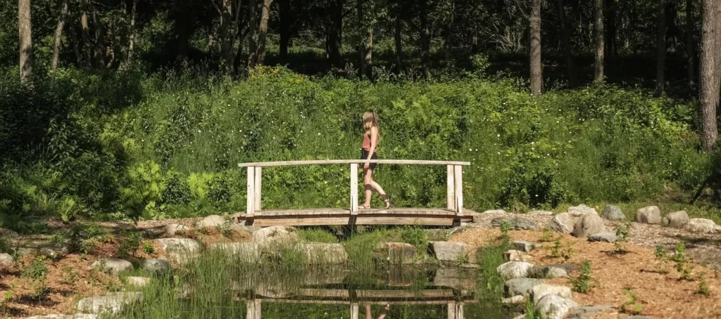 Personne marchant sur un pont en bois dans la nature.