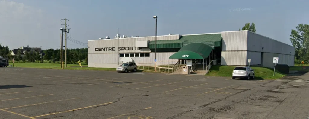 Bâtiment Centre Sport avec parking avant.