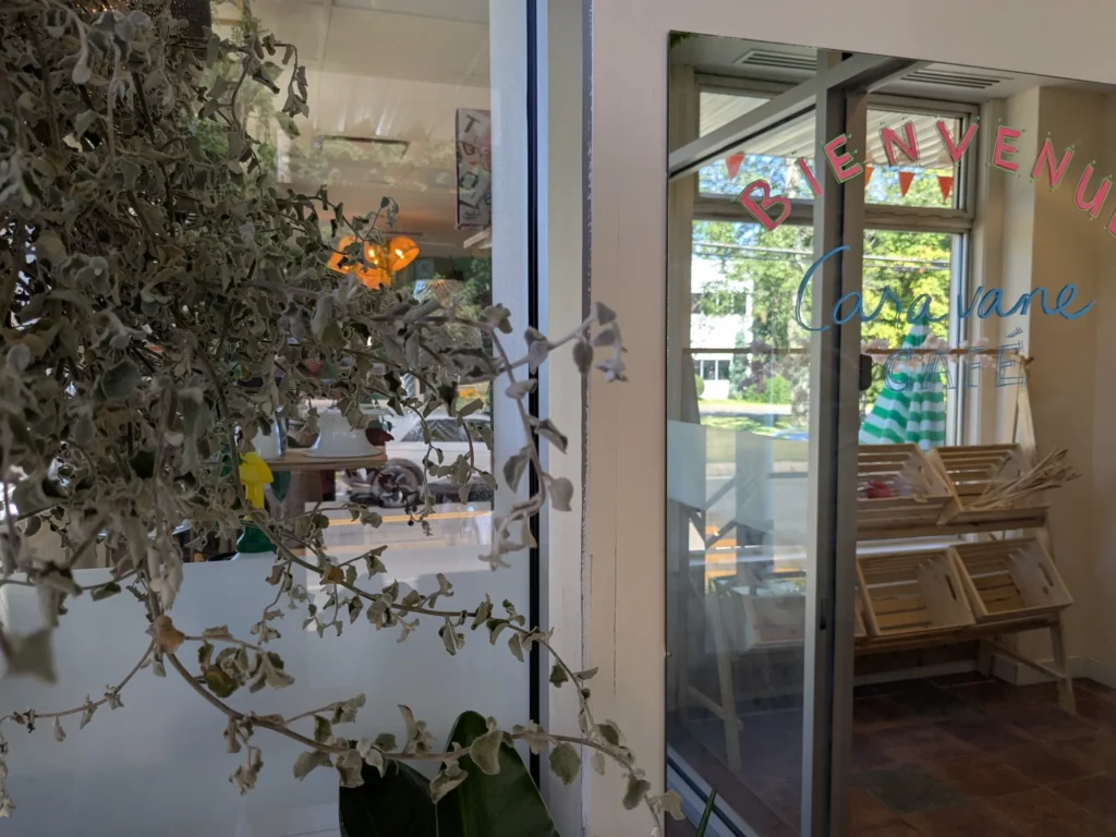 Entrée d'un café avec plantes.