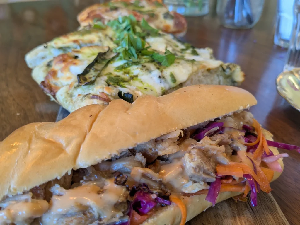 Sandwich et pizza sur une table en bois.