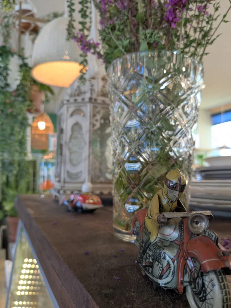 Vase en cristal avec fleurs et jouet de moto.