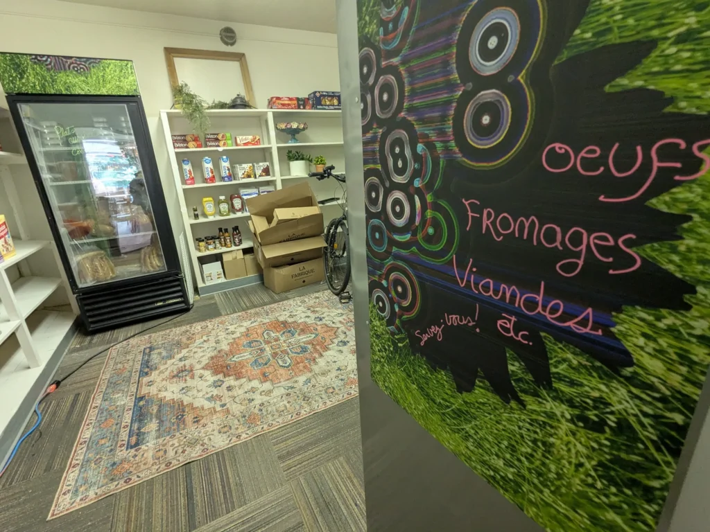 Épicerie avec frigo et étagères de produits.