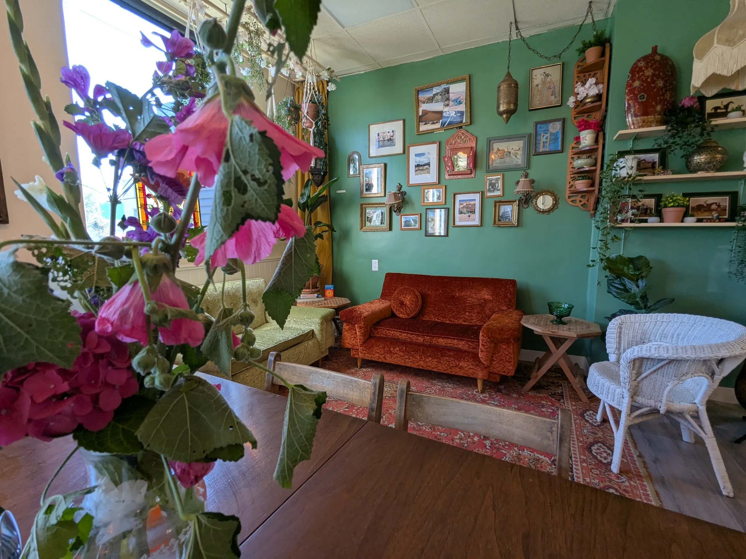 Salon coloré avec fleurs et décorations murales.