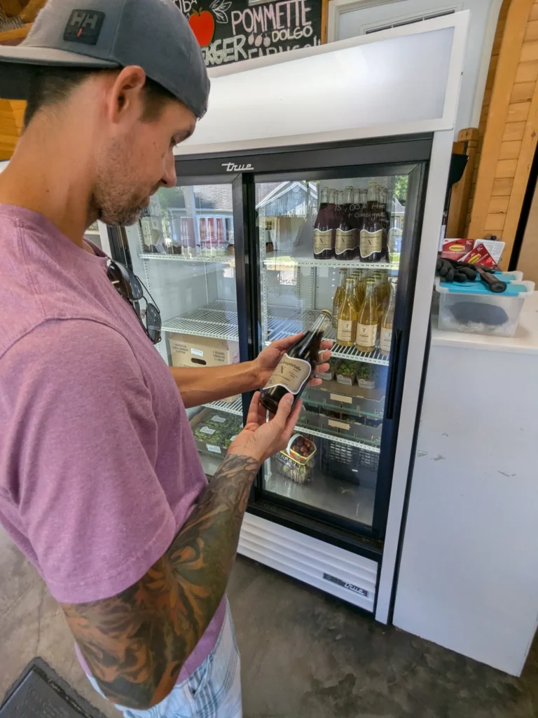 Homme choisissant du cidre dans un réfrigérateur.