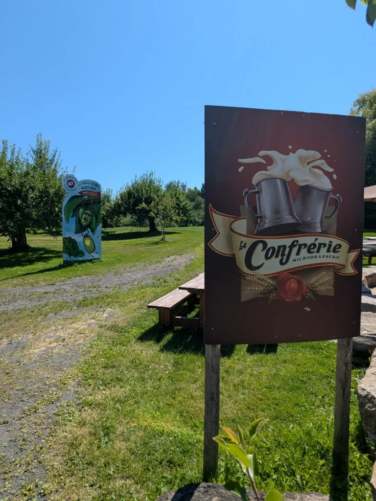 Panneau microbrasserie dans un verger ensoleillé.