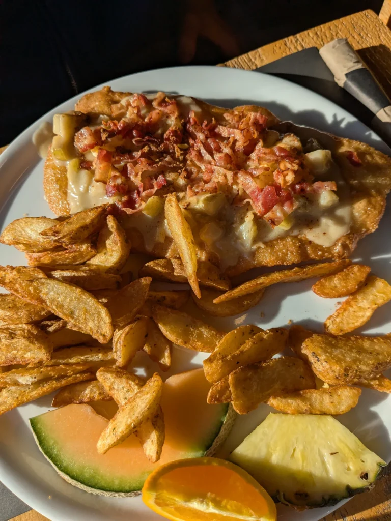 Assiette avec viande, pommes de terre et fruits frais.