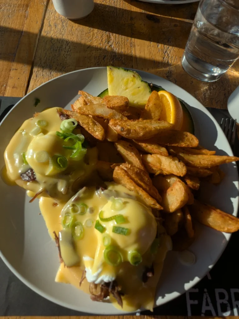 Assiette de brunch avec œufs Benedict et frites.
