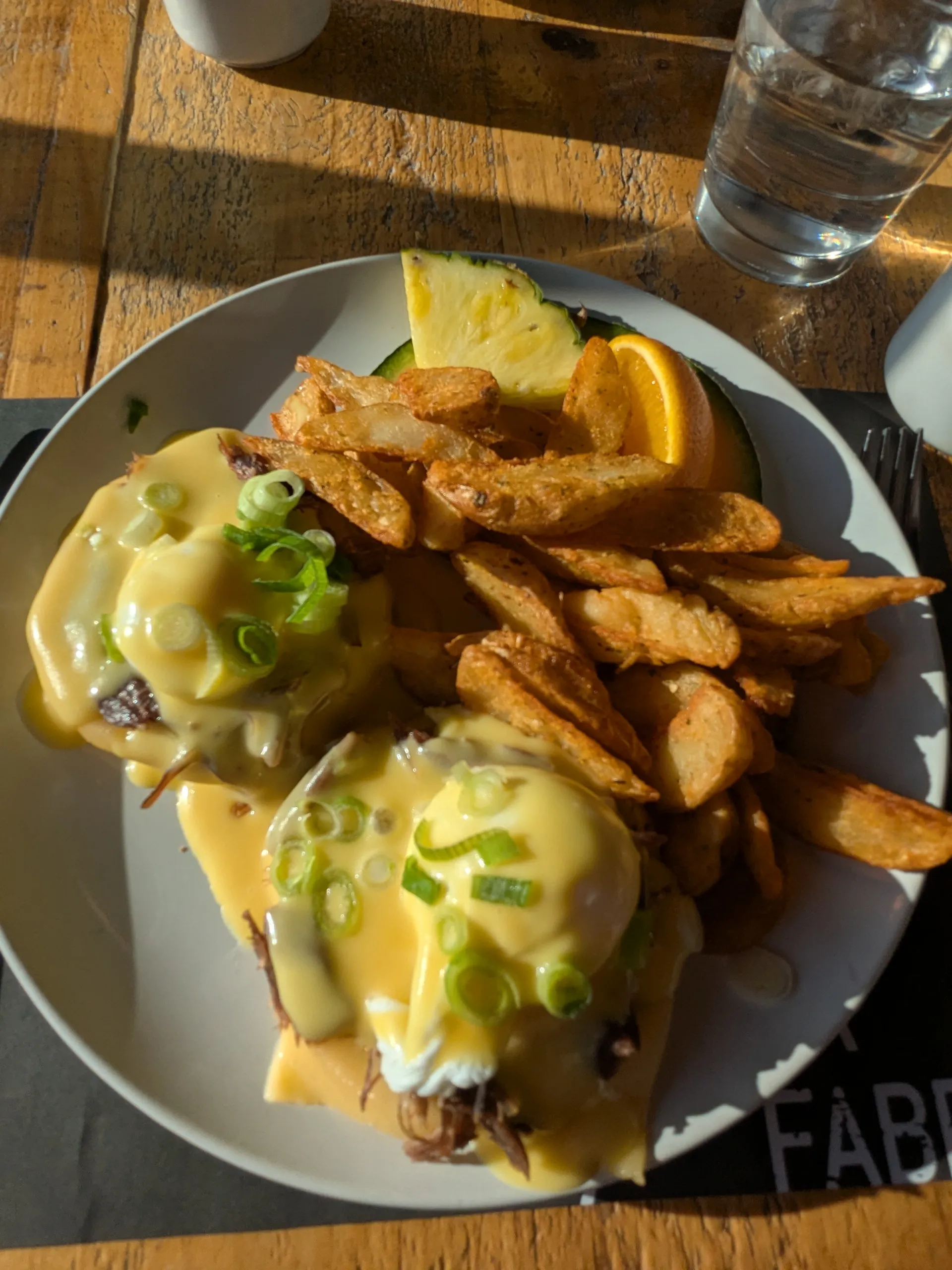 Assiette de brunch, œufs, pommes de terre, fruits.