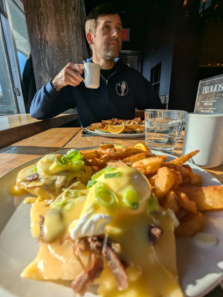 Homme savourant un petit-déjeuner ensoleillé avec café.
