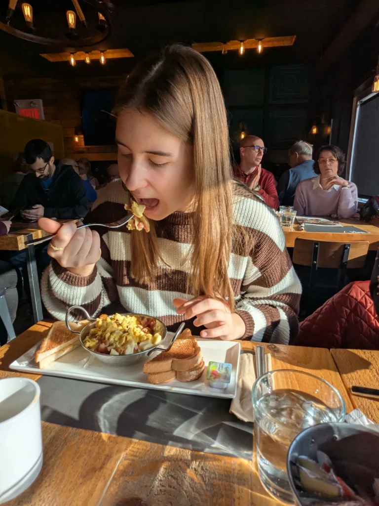 Femme mangeant des œufs brouillés au restaurant.