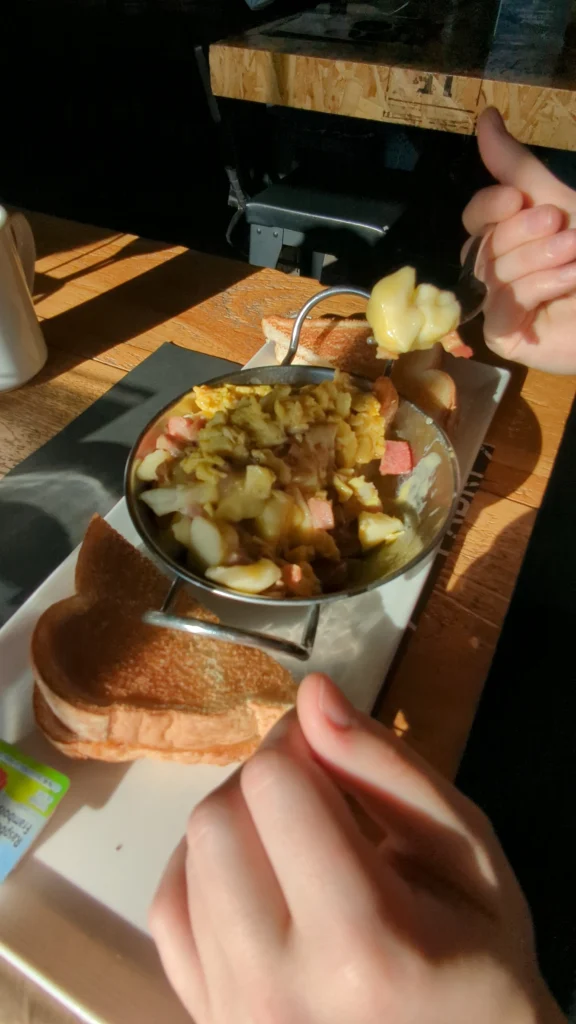 Plat fromager avec pain grillé, mains en action.